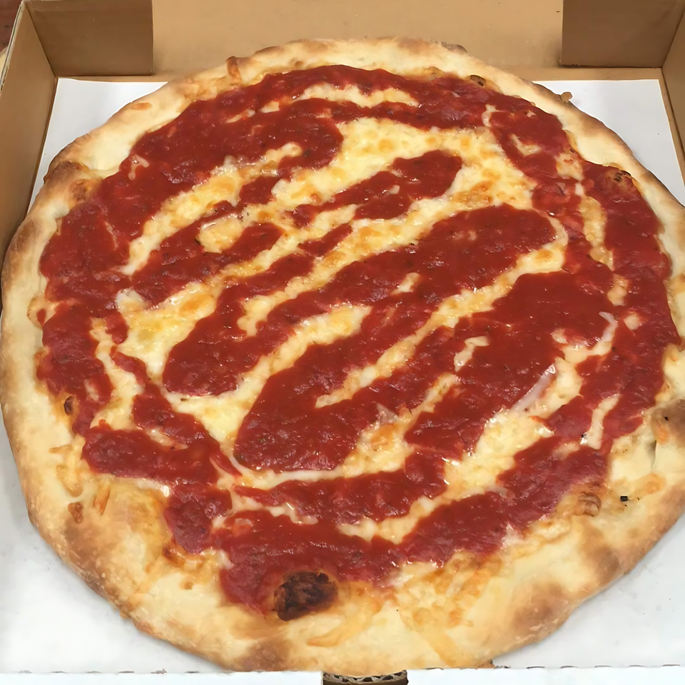 A whole cheese pizza with red sauce drizzled on top, in a cardboard box.